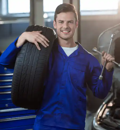 portrait mechanic carrying tyre